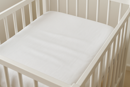 Baby crib sheet in white colour showing 2 or 3 wrinkles on the sheet